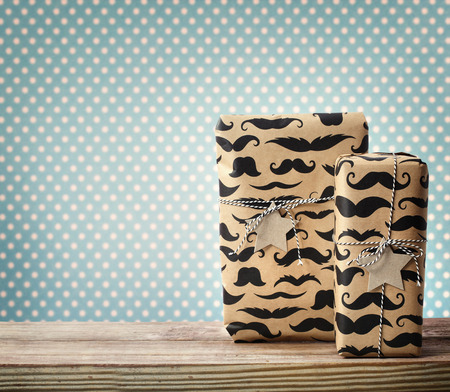 Mustache pattered gift boxes with star shaped tags over polka dots backgroundの写真素材
