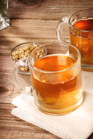 Chamomile tea with dried chamomile flowers on rustic wooden tableの写真素材