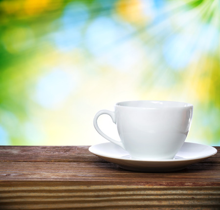 Coffee cup on shiny green with sunshine backgroundの写真素材