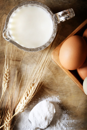 Milk, eggs and wheat flour on rustic wooden tableの写真素材