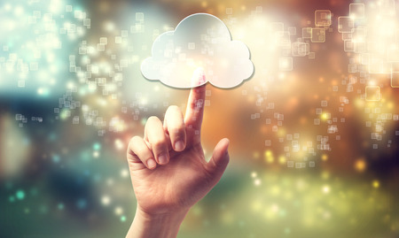 Cloud computing symbol being pressed by a persons handの写真素材