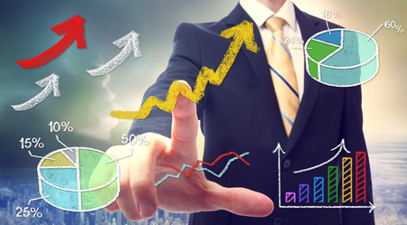 Businessman pointing at rising arrows and graph cartoonの写真素材