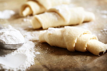 Croissants dough freshly prepared for baking with flour on wooden boardの写真素材