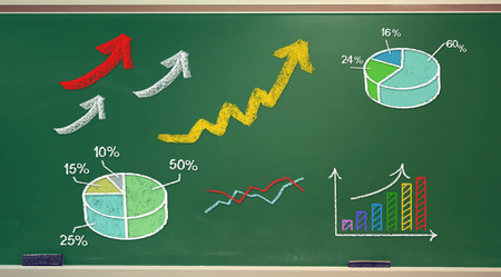 Rising arrows and graphs drawn on green chalk boardの写真素材
