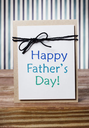 Fathers day message card on wooden board over blue striped wall の写真素材