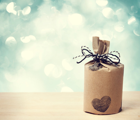 Present wrapped in a rustic earthy style on shiny blue backgroundの写真素材