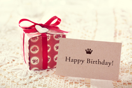 Happy birthday message written on a card with a hand crafted present box の写真素材