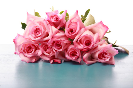 Beautiful pink roses on blue wooden boardの写真素材