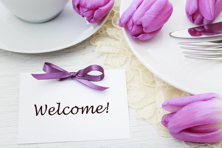 Welcome card with table setting and purple tulipsの写真素材