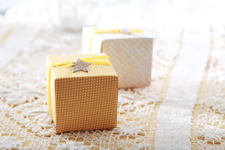 Hand made present boxes with yellow ribbons and star shaped tagsの写真素材