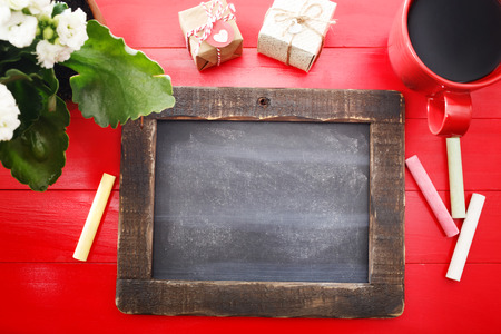 Small blank blackboard with coffee, plant and small gift boxesの写真素材