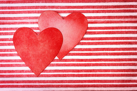 Two handcrafted paper hearts on red and white striped backgroundの写真素材
