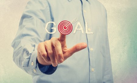 Young man in blue shirt pointing at Goal conceptsの写真素材