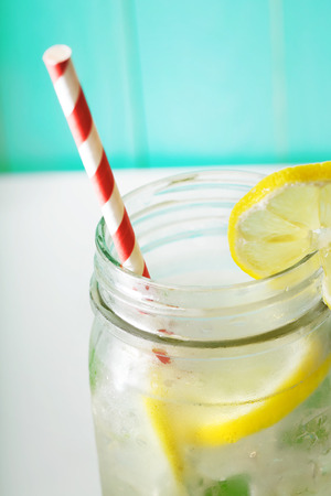 Homemade lemonade in a mason jar with big red striped strawの写真素材