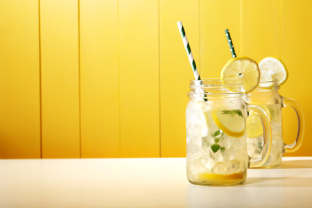 Homemade lemonade in mason jars with big green paper strawの写真素材
