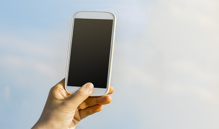 Person holding a smartphone up to the sky