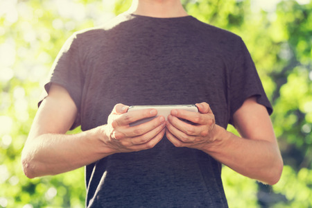 Young man using his smartphone outside at sunset
