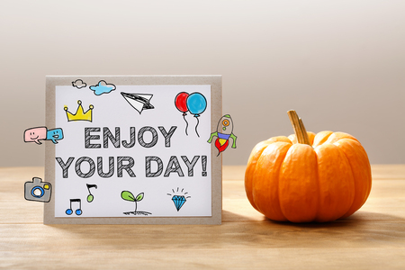 Enjoy Your Day message with a orange small pumpkinの写真素材
