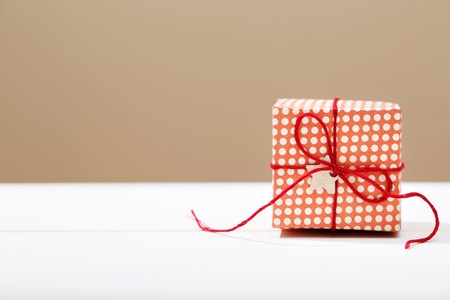 Handmade small red gift box on white wooden tableの写真素材