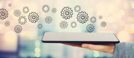 Gear concept with man holding a tablet computer