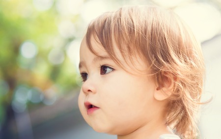 Close up portrait of a happy toddler girl outsideの写真素材