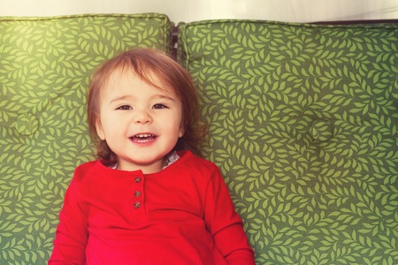 Happy toddler girl swinging on a swingの写真素材