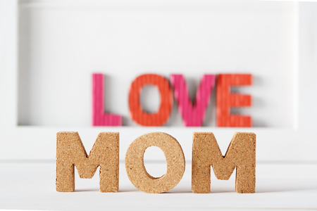 Cork Mom and paper Love texts on a white tableの写真素材