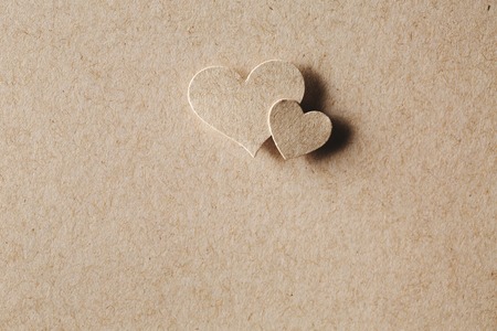Handmade paper cut hearts on erthy colored paper backgroundの写真素材