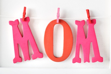 Red and pink MOM letters hanging with clothespinsの写真素材