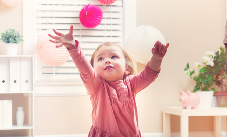 Happy toddler girl playing with toys in her houseの写真素材