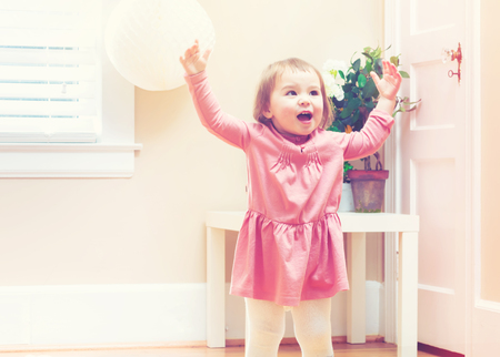 Happy toddler girl playing with toys in her houseの写真素材
