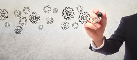 Businessman drawing gear sketch with a markerの写真素材