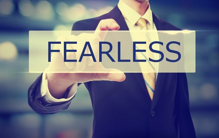 Business man holding Fearless on blurred abstract backgroundの写真素材