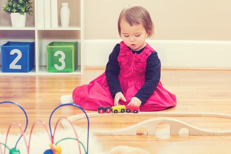 Happy toddler girl playing with toys in her houseの写真素材
