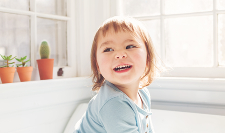 Happy toddler girl with a giant smile in her houseの写真素材