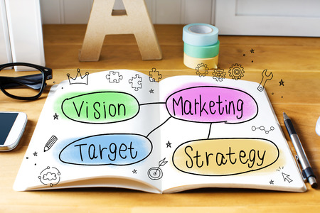 Marketing concept with notebook on wooden desk 