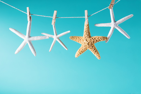 Summer theme with hanging starfish on a bright blue backgroundの写真素材