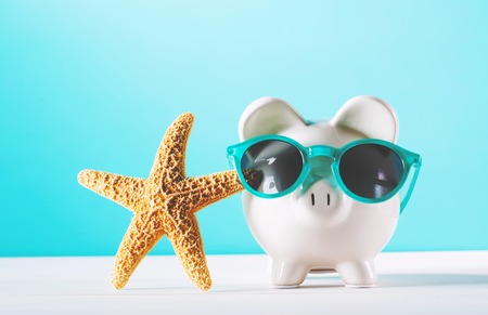 Piggy bank wearing a sunglasses with starfish on blue backgroundの写真素材