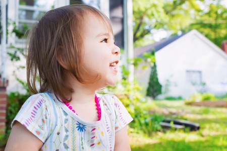 Happy toddler girl playing outside on a summer dayの写真素材