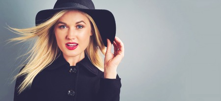 Beautiful young blonde woman in a black coatの写真素材