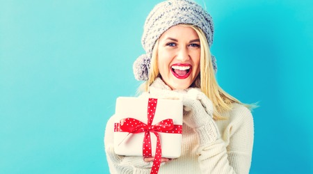 Happy young woman holding a Christmas presentの写真素材