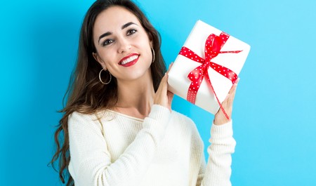 Happy young woman holding a Christmas presentの写真素材