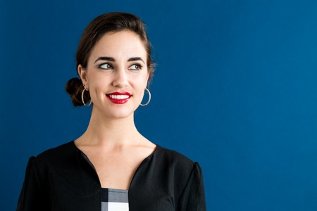 Happy young woman on a dark blue backgroundの写真素材