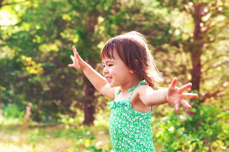 Happy smiling toddler girl playing outsideの写真素材