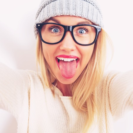 Young woman in winter clothes taking a selfieの写真素材