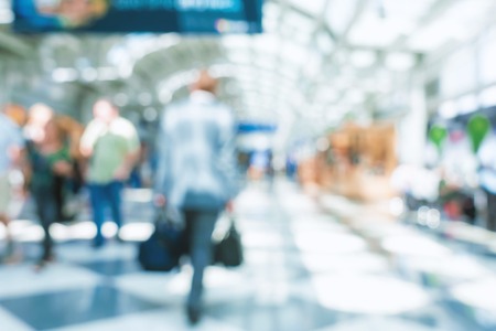 Defocused airport corridor with walking travelersの写真素材
