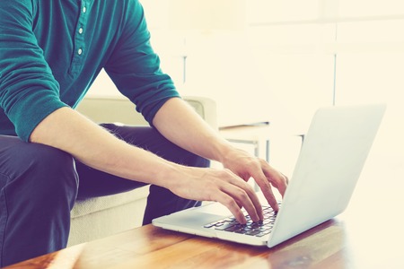 Man on a laptop in bright window lit roomの写真素材
