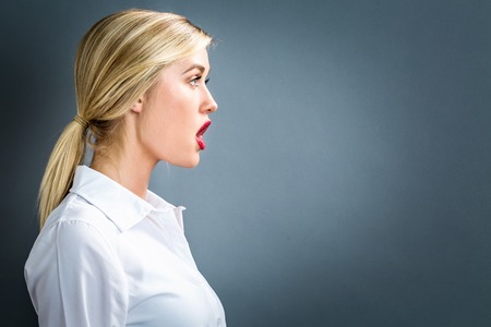Profile of a young woman on a gray backgroundの写真素材