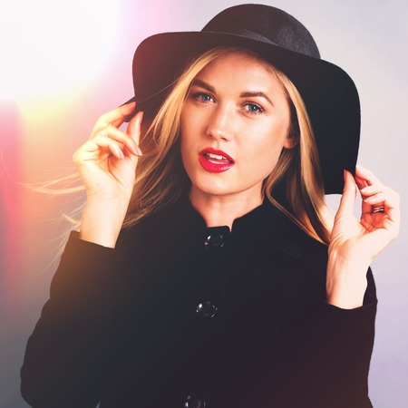 Beautiful young blonde woman in a black coatの写真素材