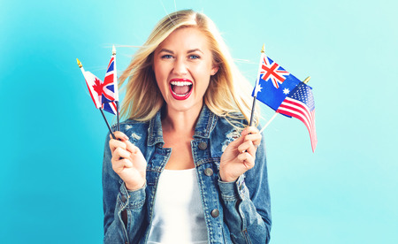 Young woman with flags of English speaking countriesの写真素材